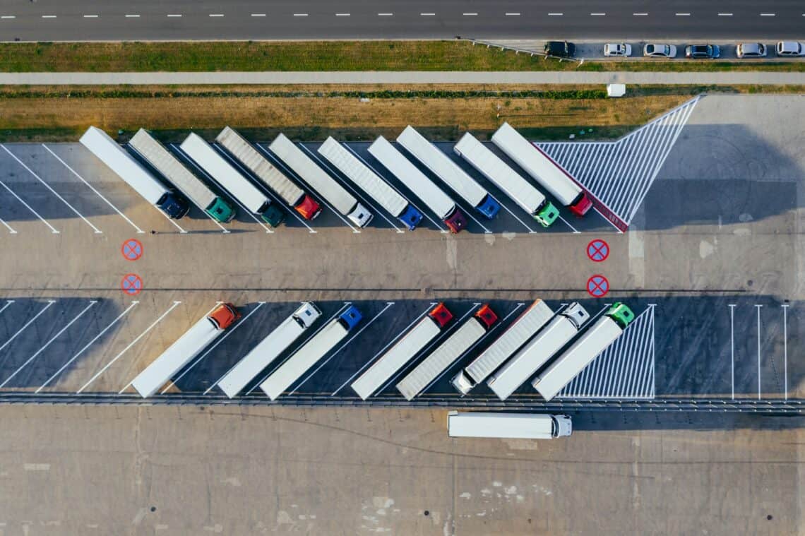 multiple trucks and carriers wait to move goods